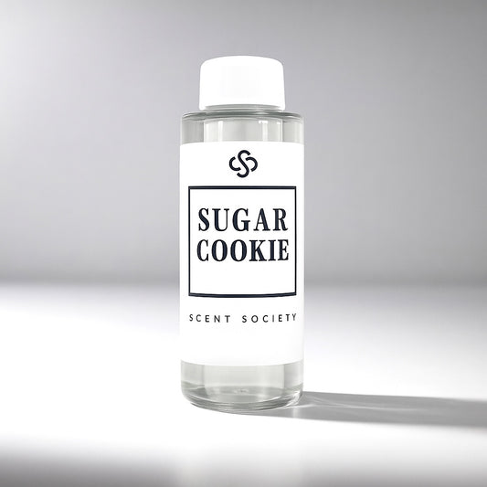 Clear diffuser oil bottle labeled 'Sugar Cookie' by Scent Society on a gray background