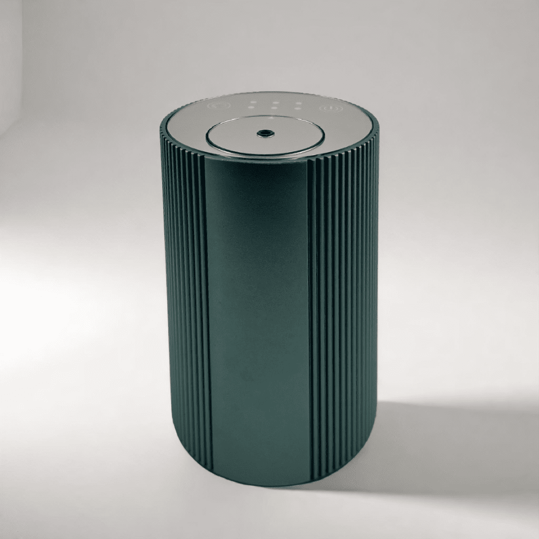 Scent Society Intro compact green diffuser with vertical ribbed texture, flat circular top, and LED indicator lights, shown standing upright on a neutral background for desktop or small space scenting.