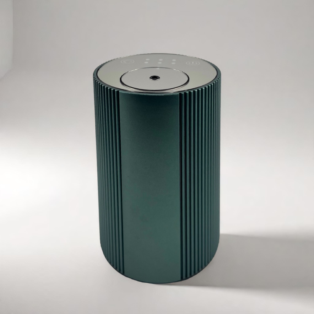 Scent Society Intro compact green diffuser with vertical ribbed texture, flat circular top, and LED indicator lights, shown standing upright on a neutral background for desktop or small space scenting.