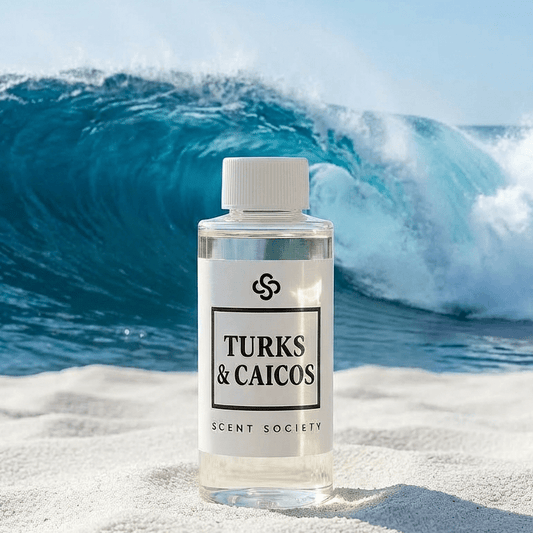 Turks & Caicos Scent Society diffuser oil bottle on a beach with blue waves in the background