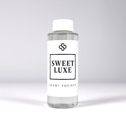 Scent Society diffuser fragrance oil in clear 100ml bottle labeled Sweet Luxe, with white cap on neutral background.