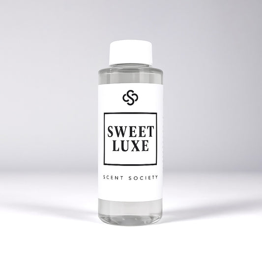 Scent Society diffuser fragrance oil in clear 100ml bottle labeled Sweet Luxe, with white cap on neutral background.
