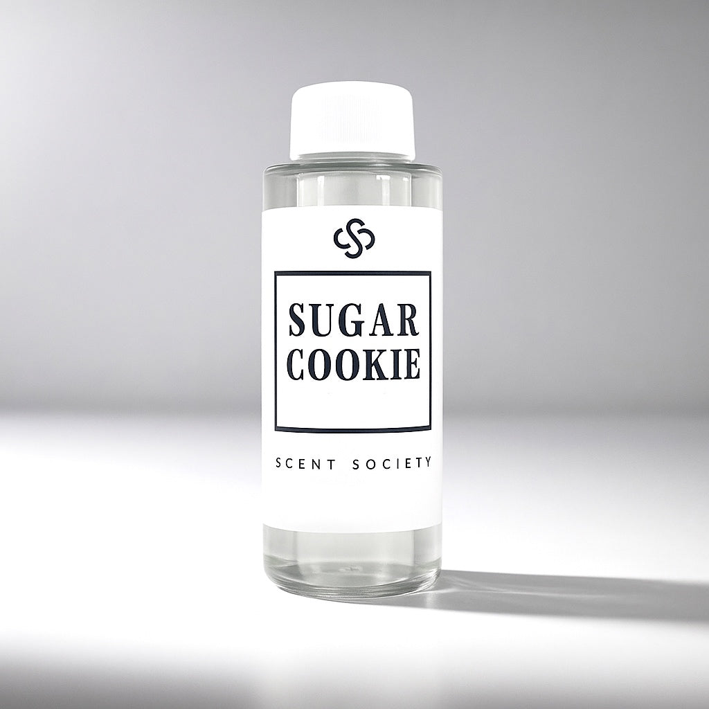 Clear diffuser oil bottle labeled 'Sugar Cookie' by Scent Society on a gray background