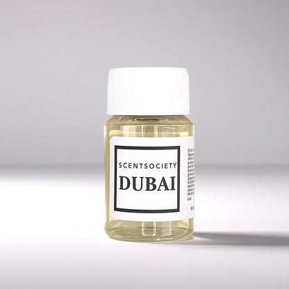 20ml bottle of Scent Society labeled 'DUBAI' diffuser oil on a neutral background. Clear plastic bottle with white cap and minimalist black-and-white label, filled with fragrance oil. Aromatherapy oil for use in cold air diffusers.