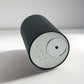 Black Scent Society Entrance Scent Diffuser cylindrical device laid on side with mirror control panel on a white background.