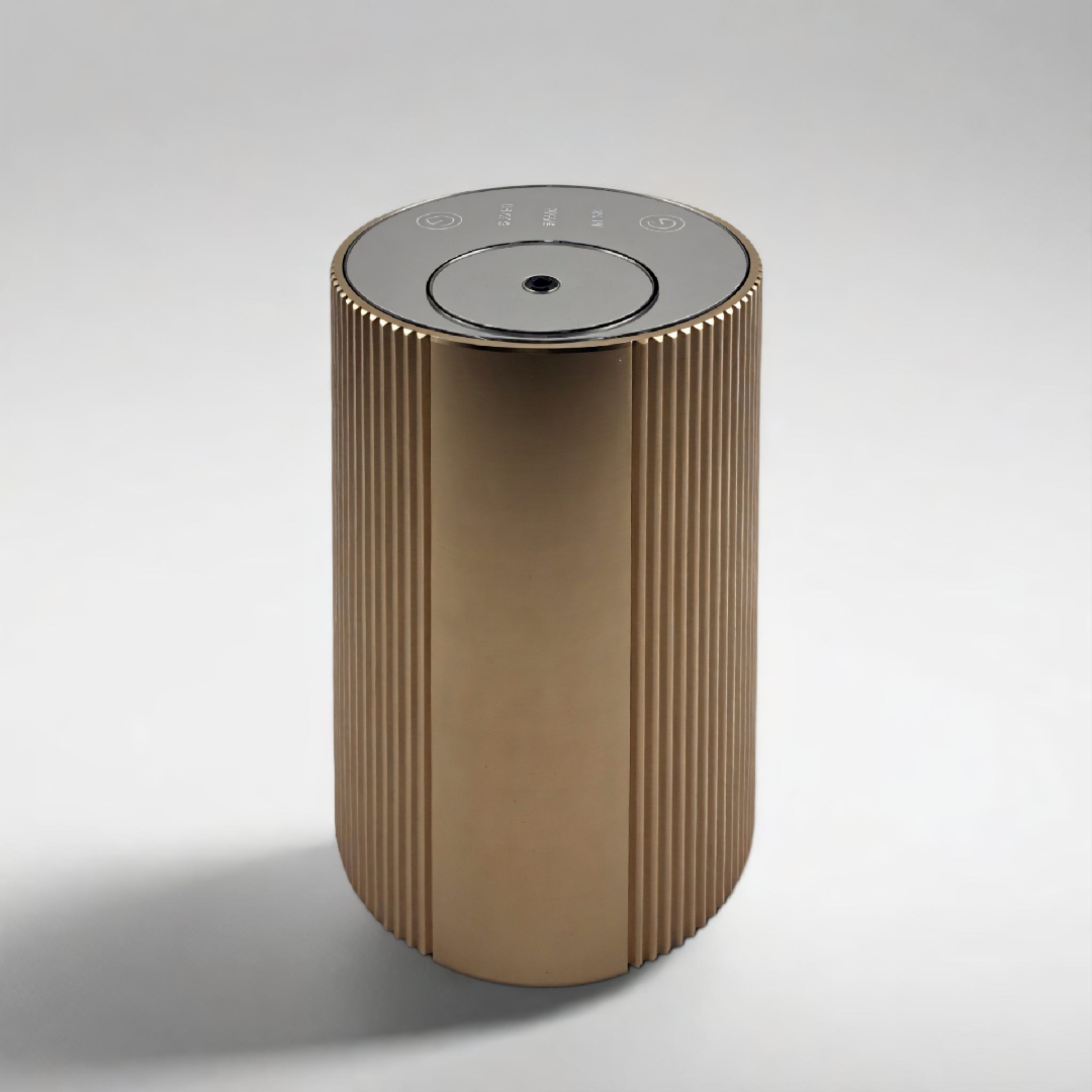 Scent Society Intro compact gold diffuser with vertical ribbed texture, flat circular top, and LED indicator lights, shown standing upright on a neutral background for desktop or small space scenting.