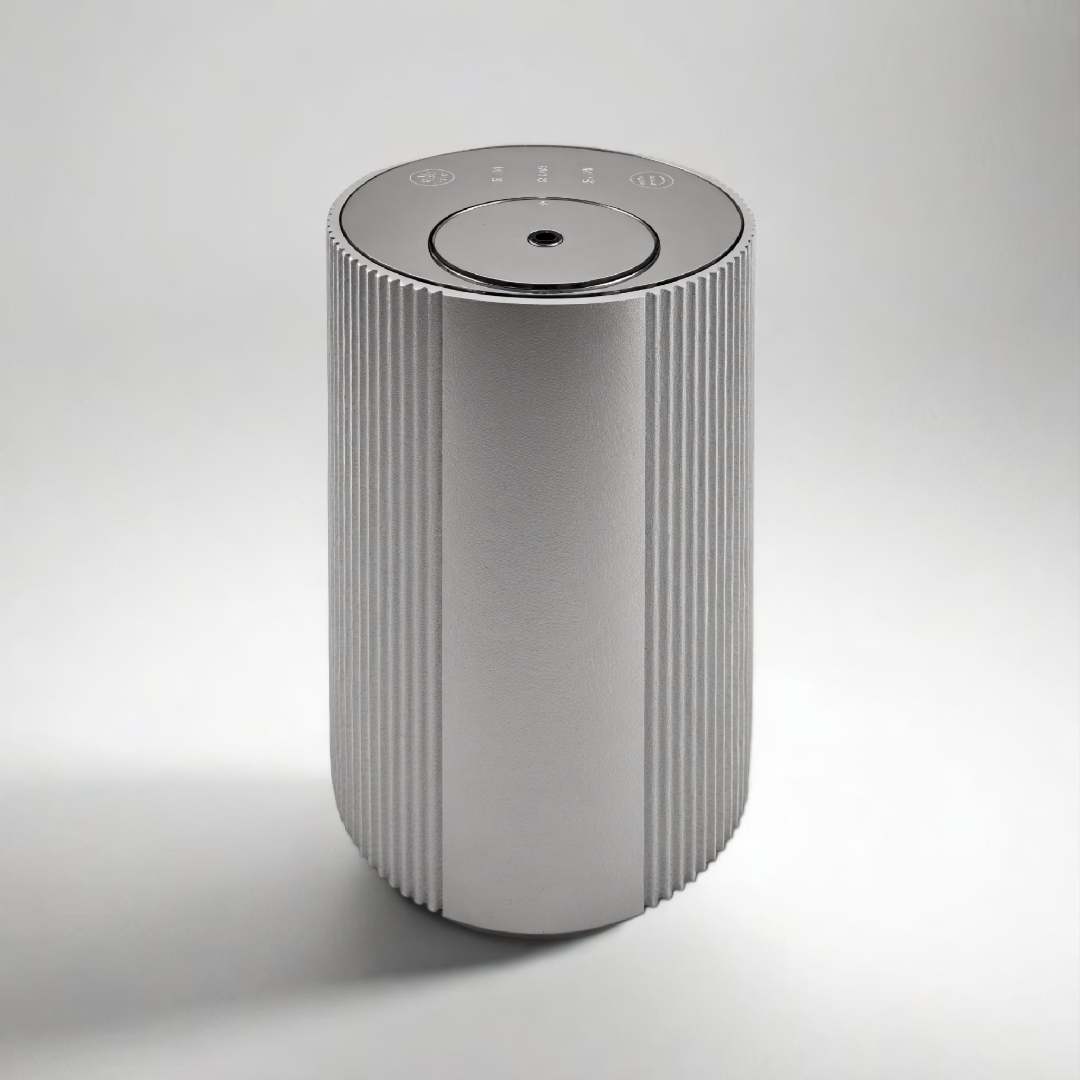 Scent Society Intro compact silver diffuser with vertical ribbed texture, flat circular top, and LED indicator lights, shown standing upright on a neutral background for desktop or small space scenting.