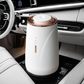 Scent Society VALET white car diffuser with rose gold trim and LED indicator shown placed. inside a modern luxury vehicle's cupholder with white leather seats and dashboard interior.