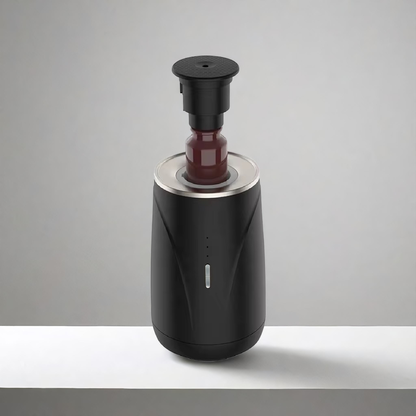 Scent Society Valet black portable car diffuser shown open with a glass fragrance oil bottle inserted vertically, featuring a matte finish, LED indicator lights, and metallic trim, displayed on a neutral background.