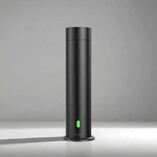 Black cylindrical diffuser machine with minimalist design and green LED light โ scent diffuser for home or office use.